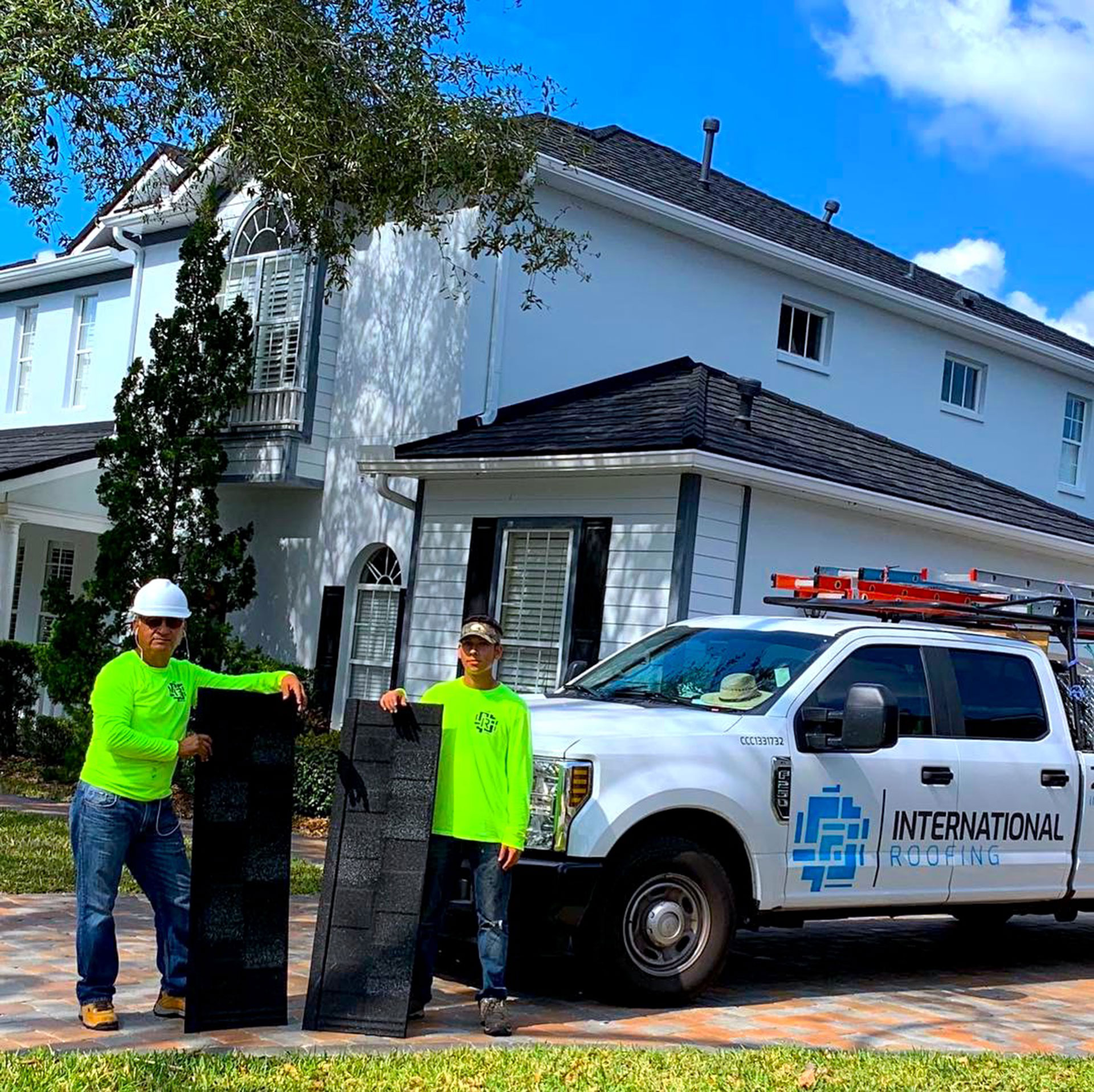 father son duo hold stone coated steel during the installation of stone coated steel in naples florida